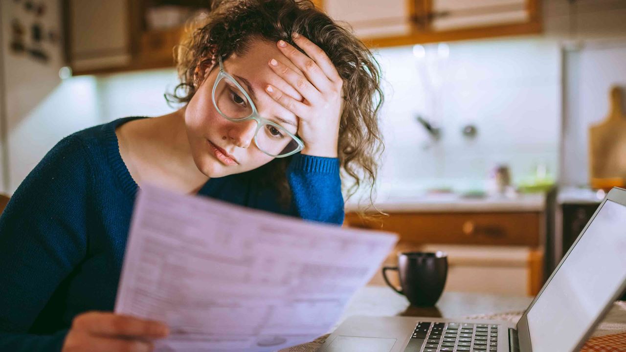 bespectacled-woman-looking-worriedly-at-papers