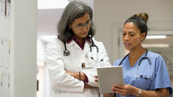 mixed race doctor discussing documents with nurse
